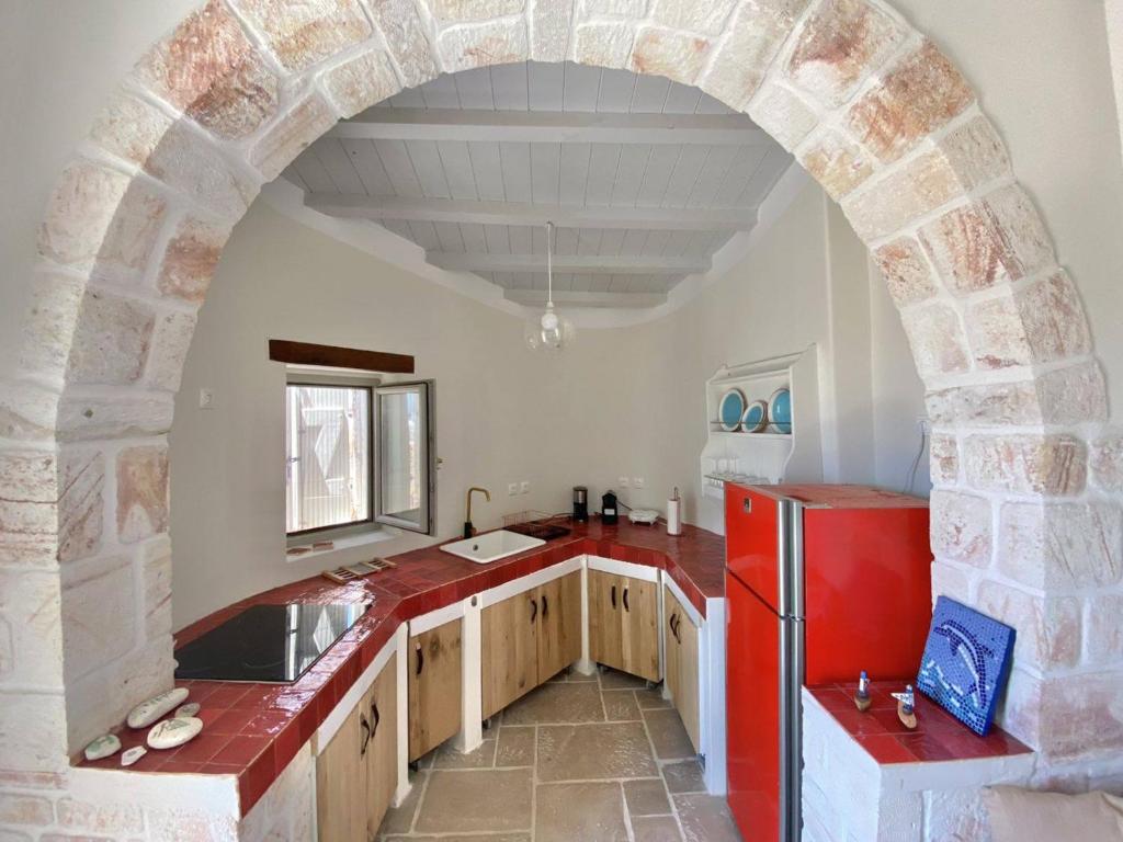 基莫洛斯岛Fournos的厨房里的拱门,配有红色冰箱