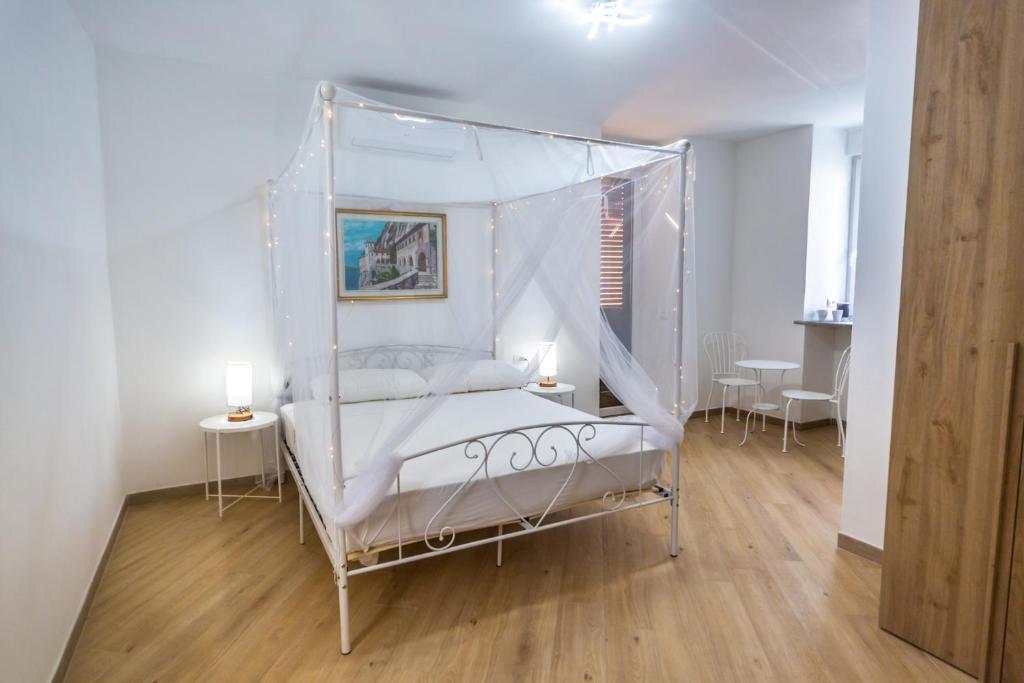 里诺迪莱吉诺Around Lago Maggiore rooms的一间卧室配有一张带两张桌子的天蓬床