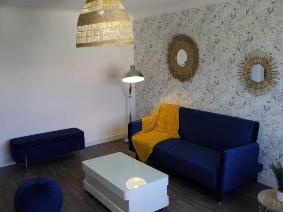 卡尔卡松Spacieux appartement au pied de la cité médiévale的客厅配有蓝色的沙发和桌子