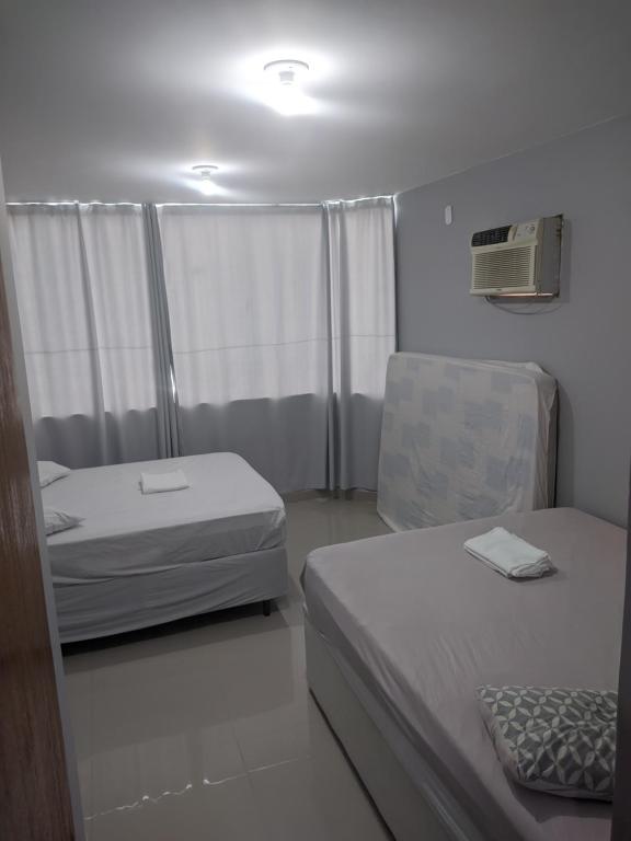 卡波布里奥Duplex Cabo frio I的一间小卧室,配有两张床和窗户