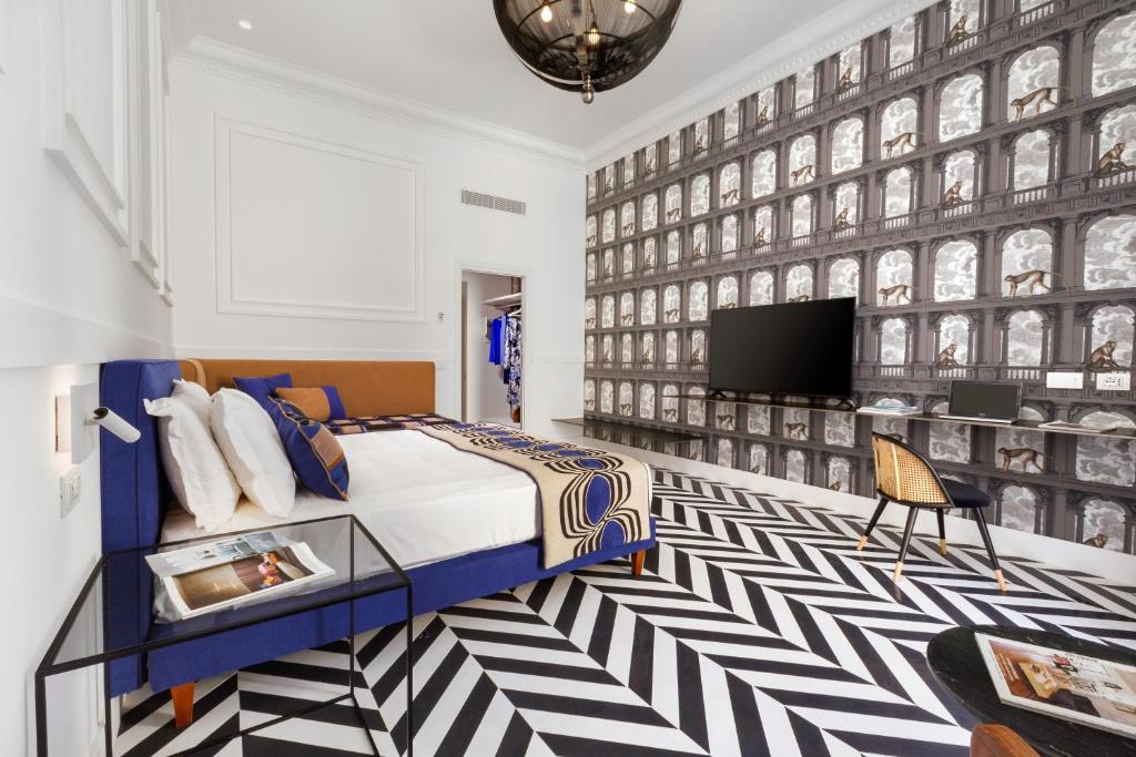索伦托YourHome - Maison Iovino Luxury Rooms的一间卧室配有一张床,墙上配有电视