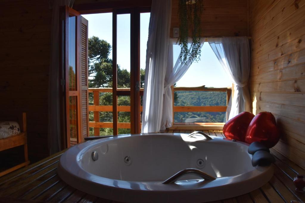 圣弗朗西斯科-迪保拉Pousada Recanto Vale da Serra Chales的窗户客房内的大浴缸