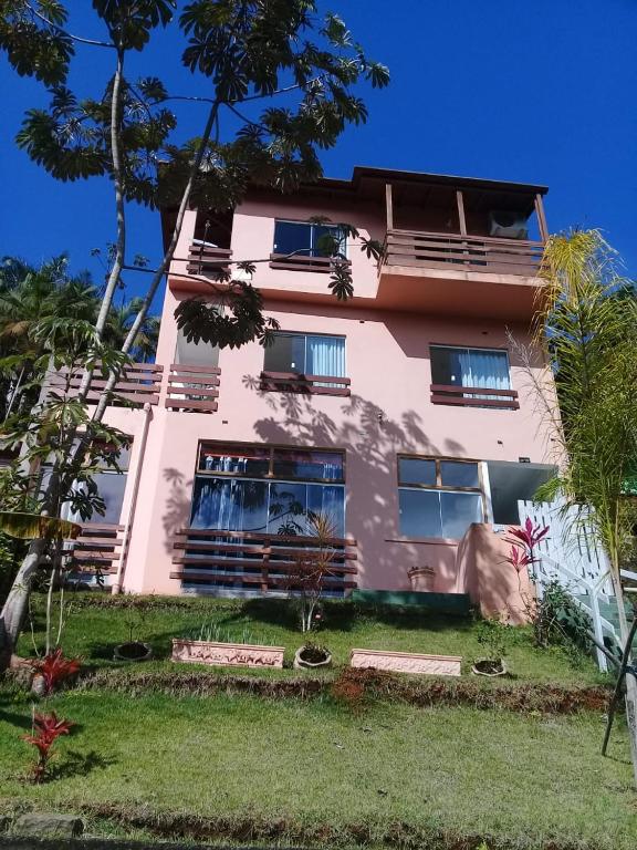 乌巴图巴La Casa Rozada Prumirim的前面有树木的粉红色建筑
