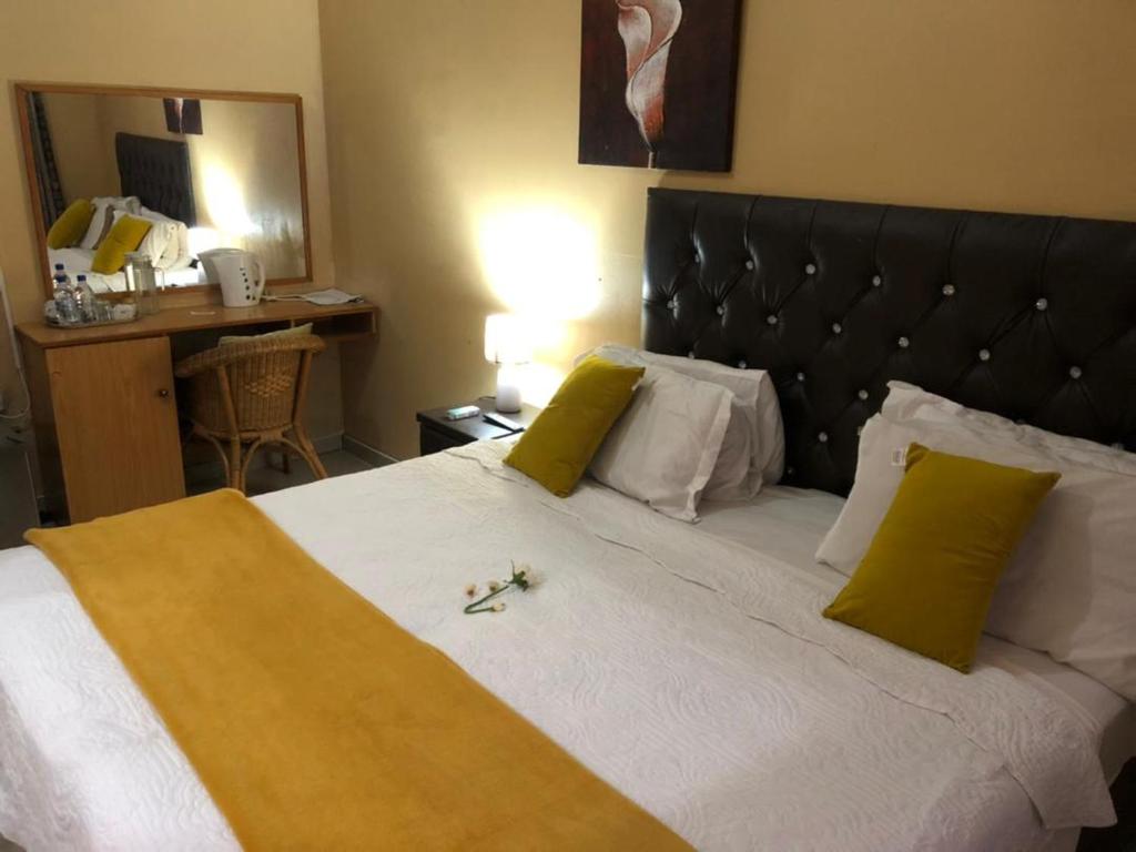 弗朗西斯敦Ntshe River Lodge的一间卧室配有一张带黄色和白色枕头的大床