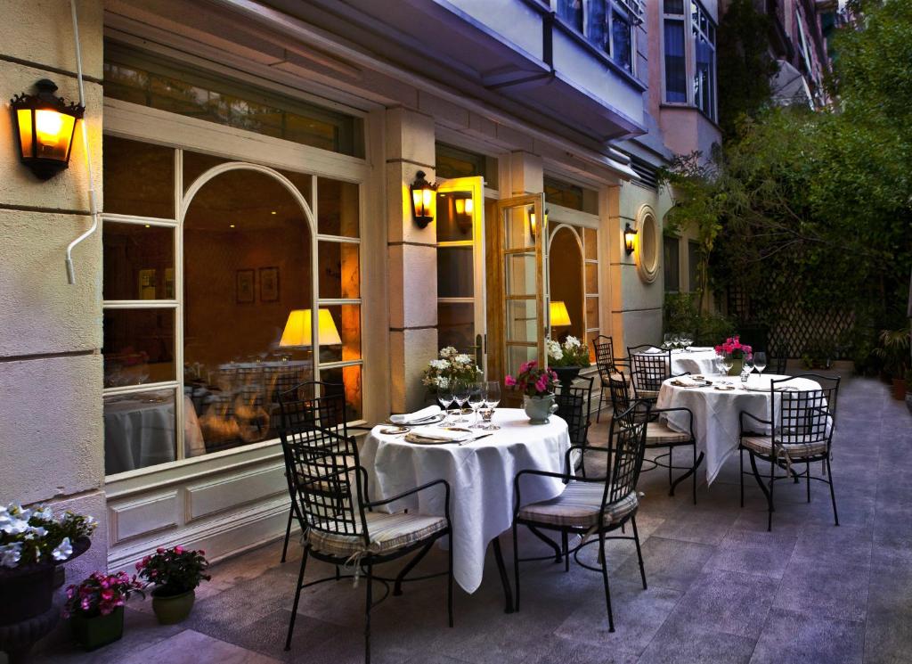 马德里Relais & Châteaux Hotel Orfila的庭院内的餐厅,配有桌椅