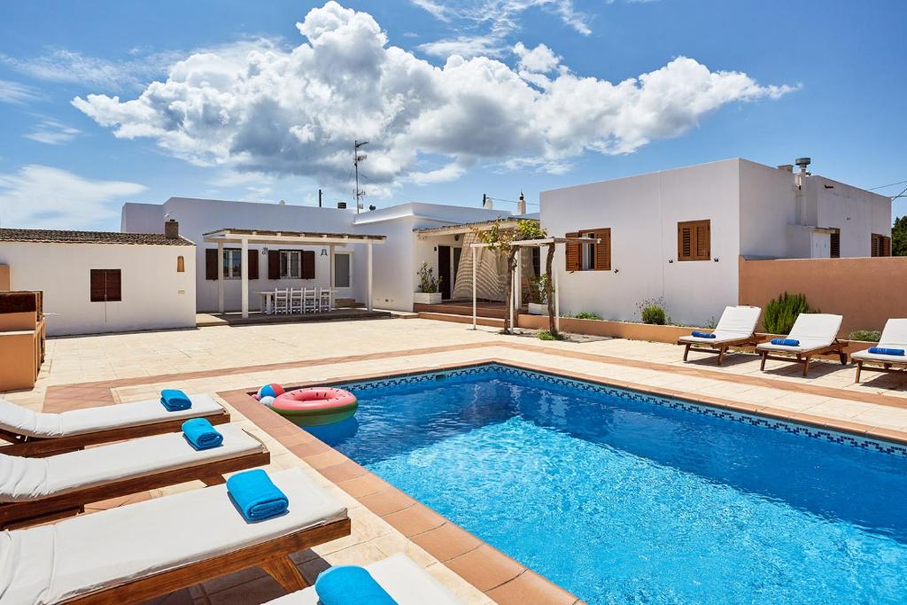 埃斯普霍斯V Es Pujols Formentera rustick的一个带椅子的游泳池以及一座房子