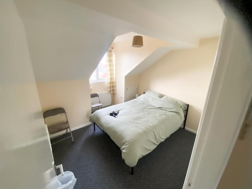 西布罗姆维奇Headrose House的卧室配有白色的床和2把椅子