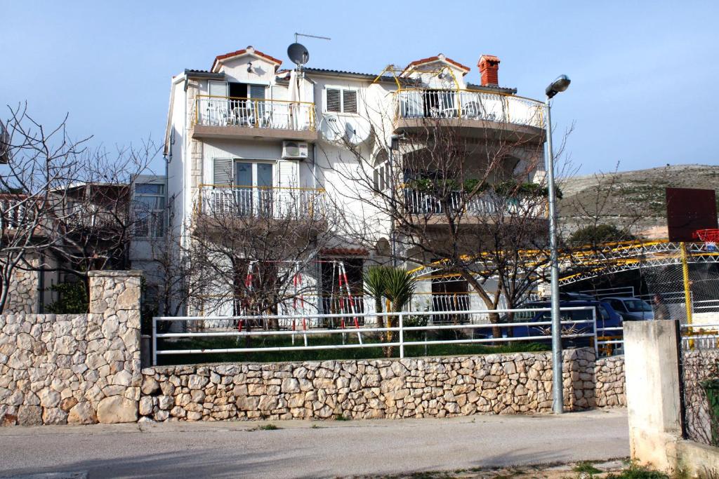 格雷巴蒂卡Apartments with a parking space Grebastica, Sibenik - 4867的一座建筑,在石墙顶部设有两个阳台