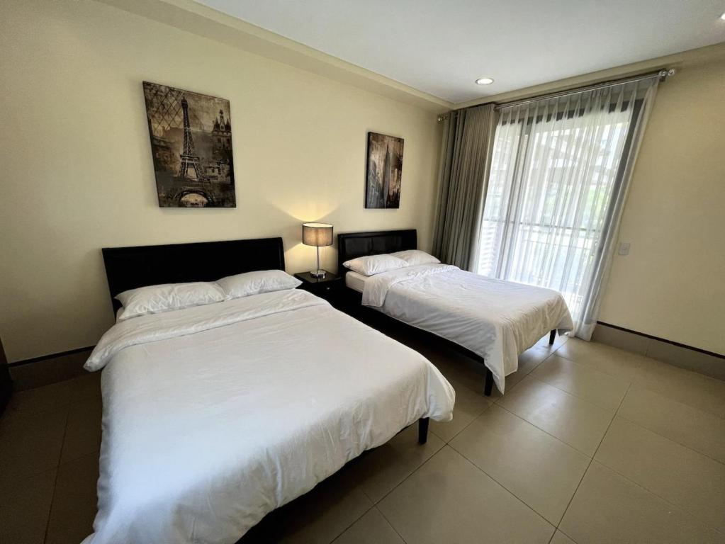 莫龙Anvaya Cove Short Term Rental Condos的一间卧室设有两张床和窗户。