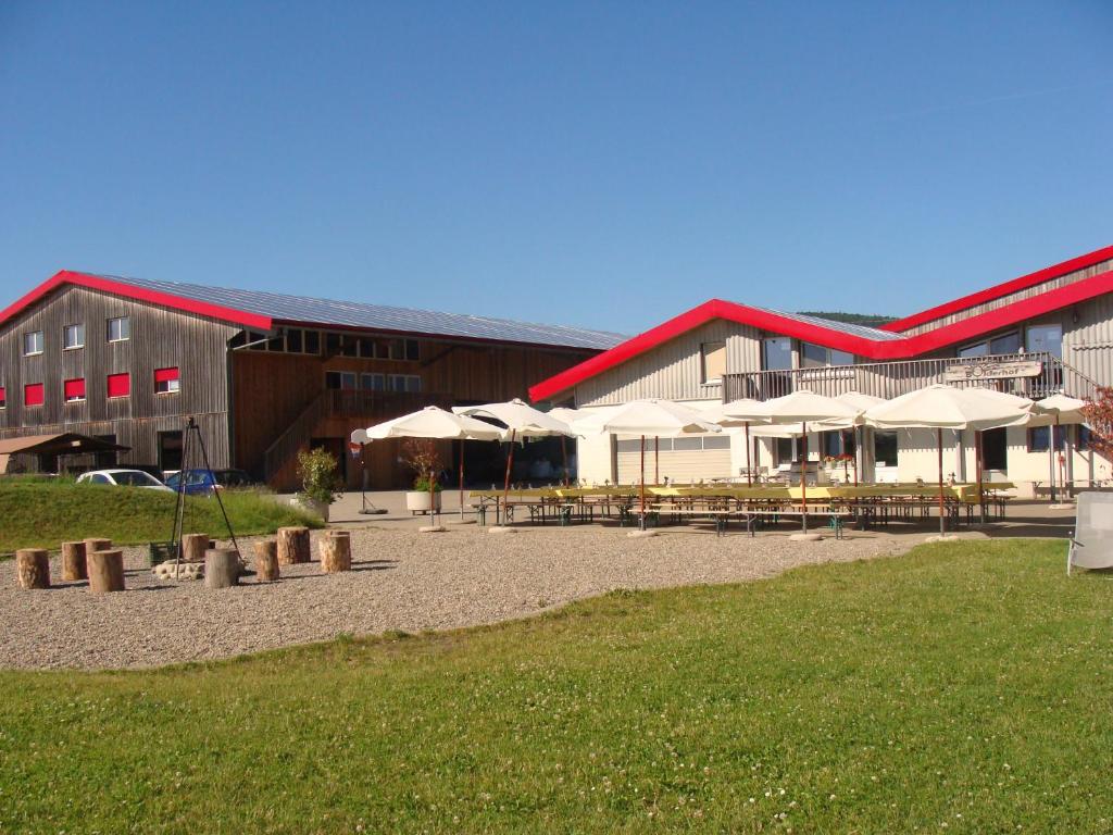 Hemishofen博德霍夫农家乐的前面有桌子和伞的建筑