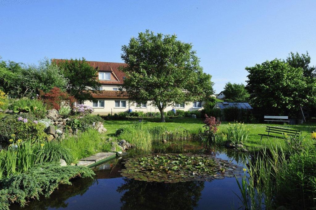 鲁博斯托夫加斯特豪斯族姆若思博格酒店的一座花园,在一座建筑前设有一个池塘
