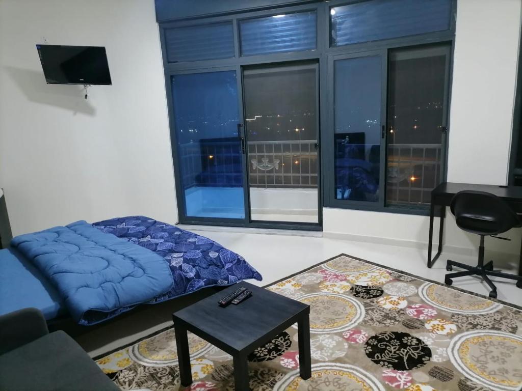 Umm el ‘AmadDurrat Al Israa的客厅设有床和大窗户