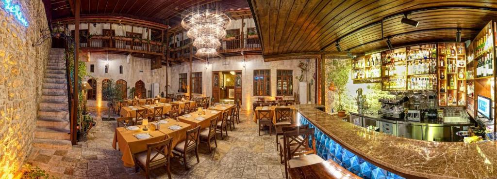 哈塔伊Le Reve Butik Otel的一间带桌椅的餐厅和一间酒吧