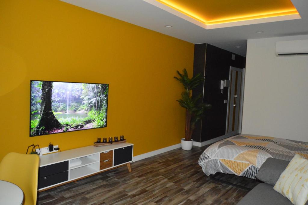 多列毛利诺斯DIAMOND TORREMOLINOS TROPICAL的一间黄色墙壁上配有电视的卧室