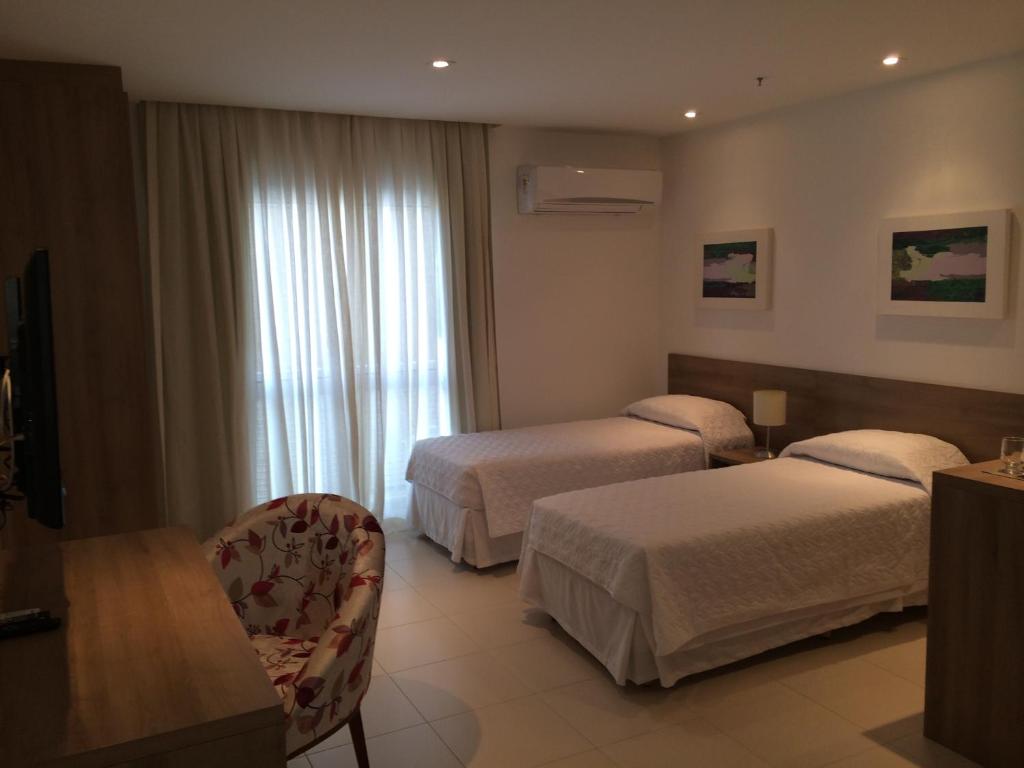 新伊瓜苏梦布隆钻石公寓式酒店的酒店客房设有两张床和窗户。