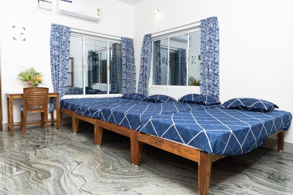 蓬蒂切里BrightMoon_Homestay的一间卧室配有一张带蓝色棉被的大床