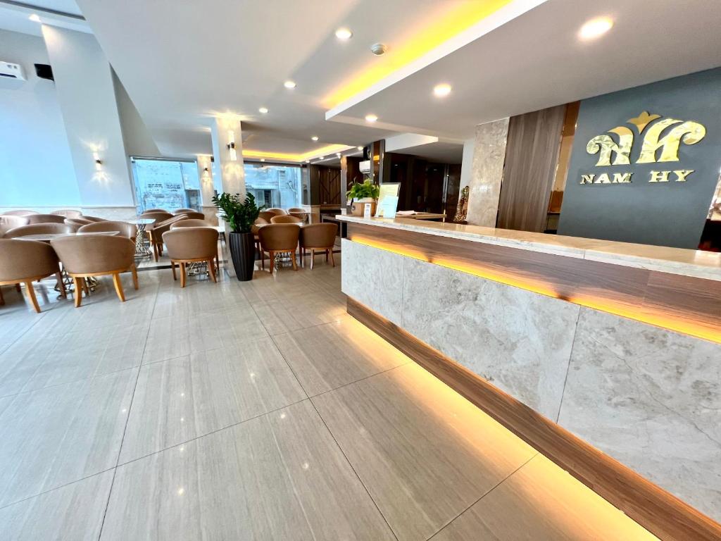 胡志明市Nam Hy 1 Hotel的餐厅设有酒吧和桌椅