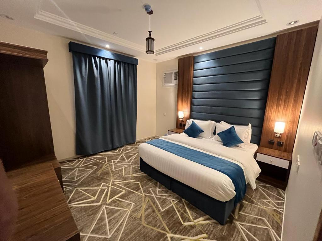 艾卜哈فيو إن للشقق الفندقية - المحالة的一间卧室配有一张带蓝色枕头的大床
