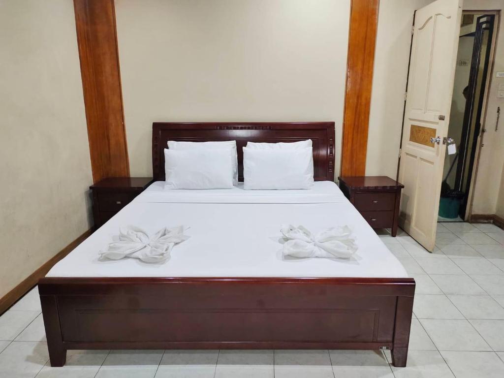 卡加盐德奥罗Parkview Hotel的一间卧室配有一张带白色床单和两个弓的大床