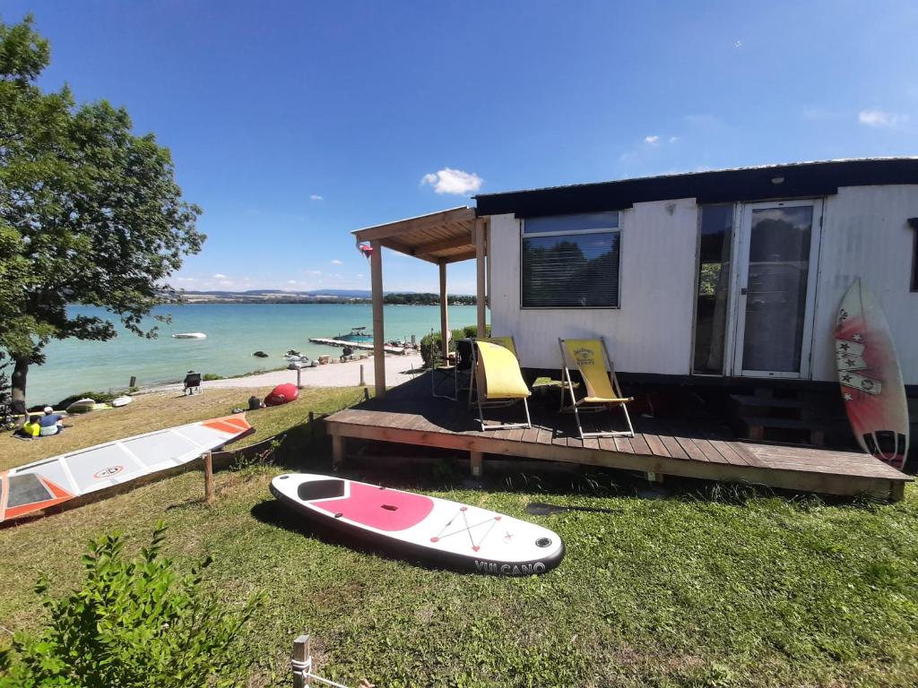 Velká JeseniceRozkoš beach mobilheim的水边草地上有两个冲浪板的房子