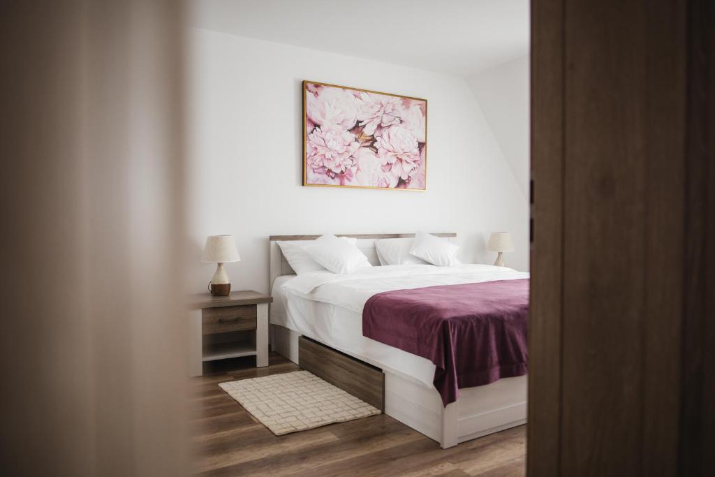 锡比乌Vila Helena的卧室配有白色床和紫色毯子