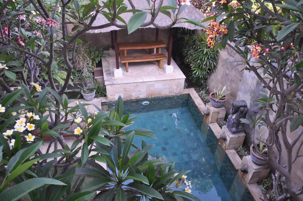 沙努尔Ngetis Home Stay的花园内带椅子的小型游泳池