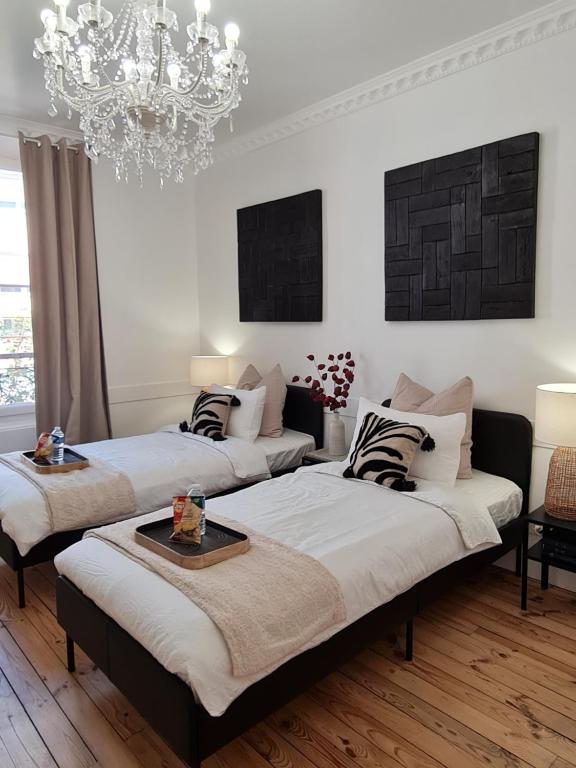 维希RoomChic - Les Ambassadeurs的一间卧室配有两张床和吊灯。