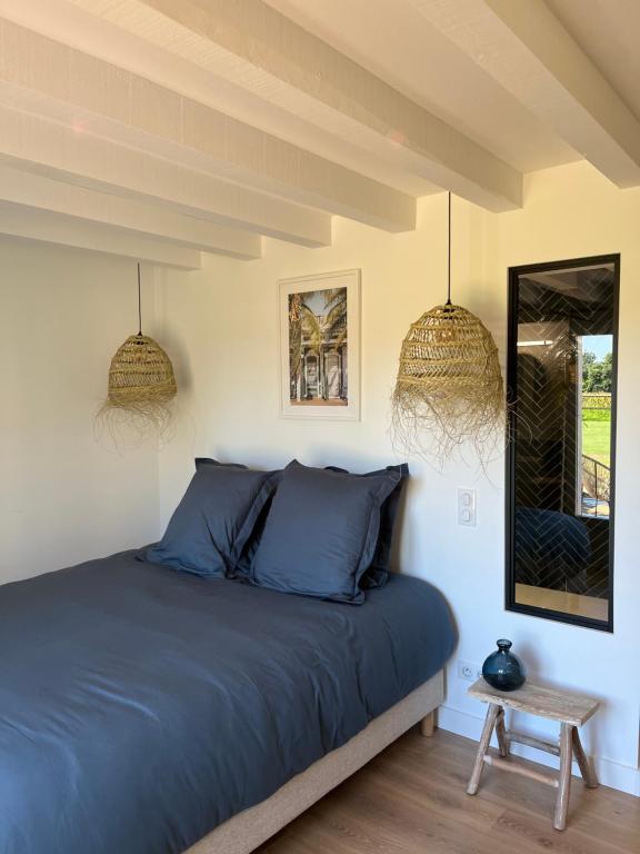 圣茹尔德马朗讷Le Ranch Kabahina Golf的一间卧室配有蓝色的床和镜子