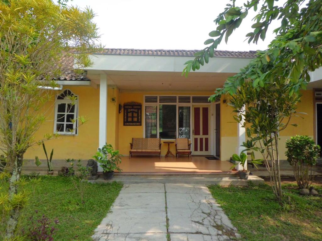 婆罗浮屠艾法塔民宿的黄色的房屋,设有庭院
