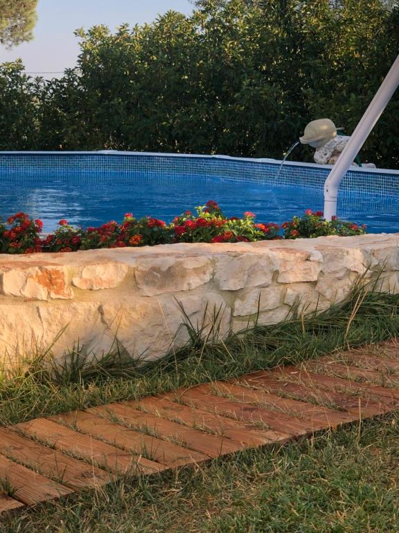 马丁纳弗兰卡Villa Messerà的游泳池旁带鲜花的挡墙