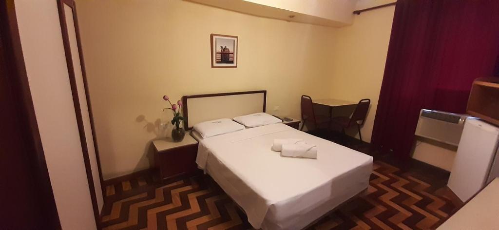 里约热内卢伊塔茹巴酒店的一间小卧室,配有一张床和镜子