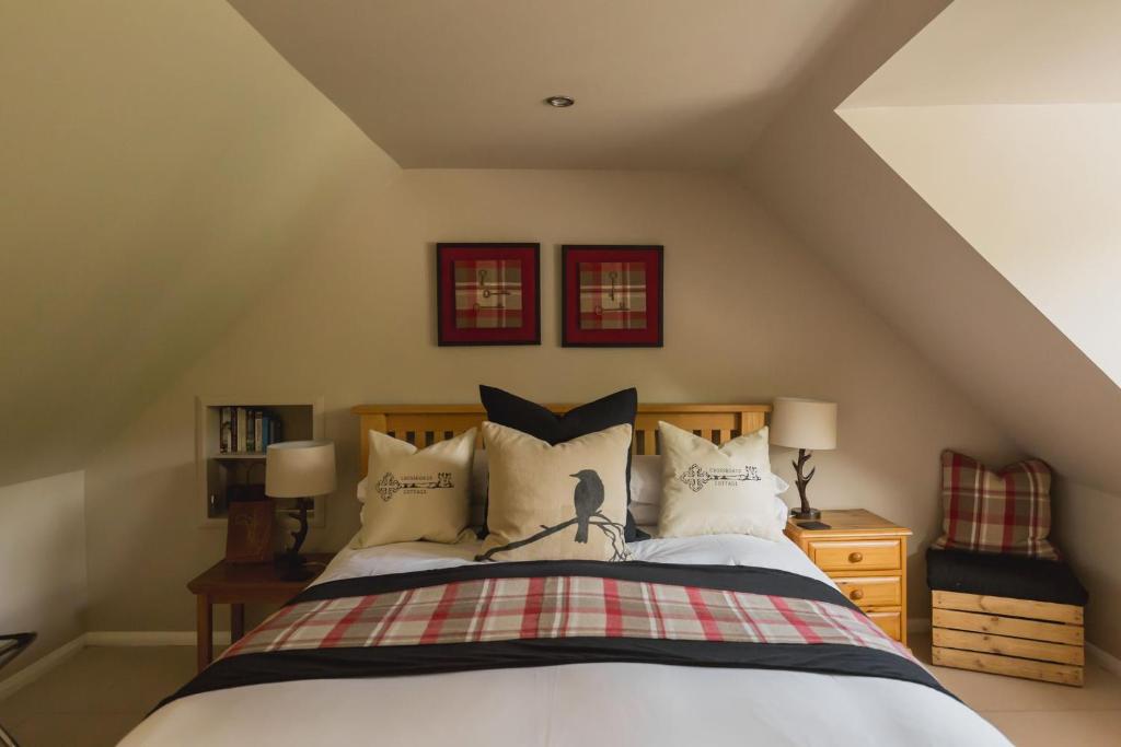 德拉姆纳德罗希特Crossroads Cottage的一间卧室配有带白色床单和枕头的床。