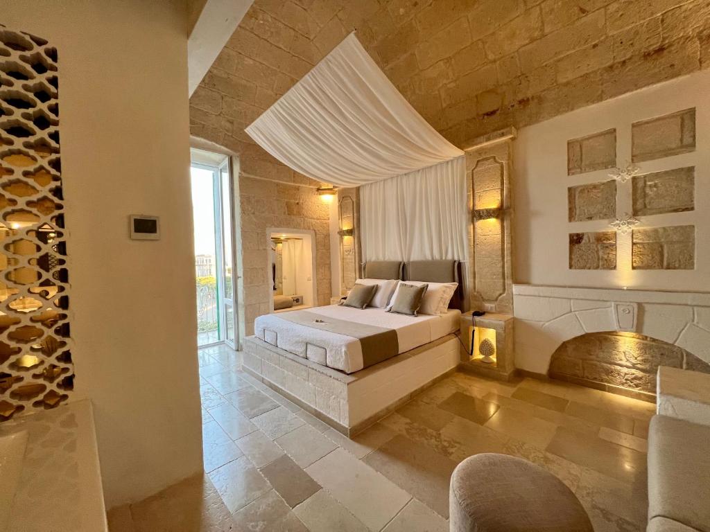 莫诺波利Vittorio Emanuele Charming Suites的一间大卧室,配有一张床和一个壁炉