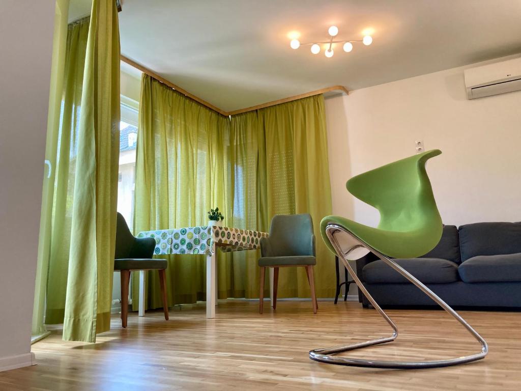 索非亚Orfey Apartment的客厅配有绿色椅子和沙发