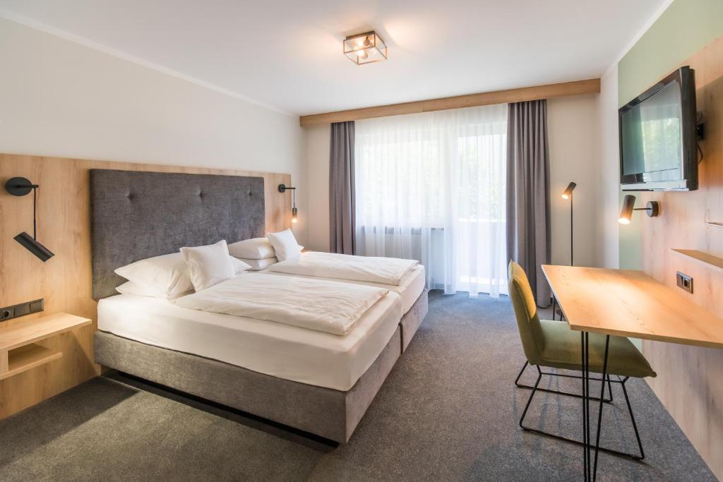 波滕施泰因施万酒店的酒店客房设有一张大床和一张书桌。