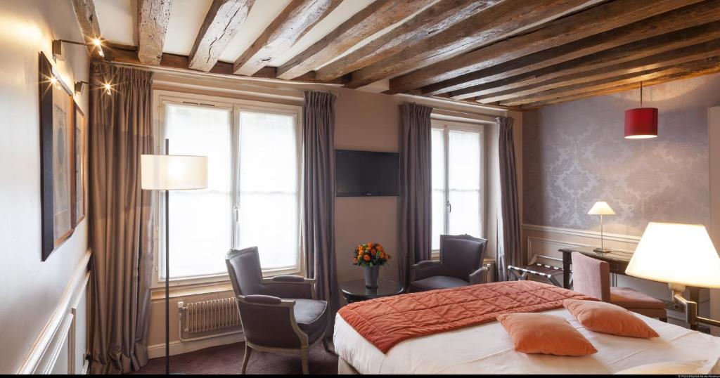 巴黎大学酒店的一间卧室,卧室内配有一张床和椅子