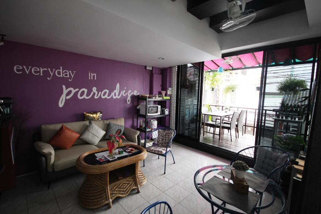 华欣Hua Hin Paradise Guesthouse的客厅配有沙发和桌子