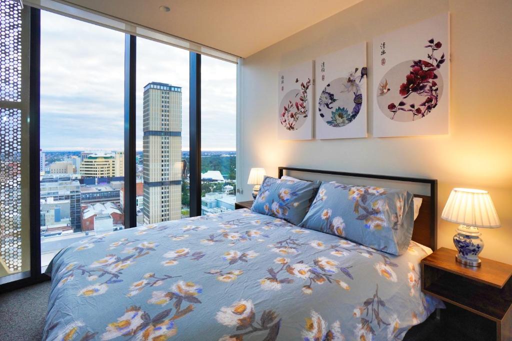 阿德莱德Luxury City Zen Apartment Rundle Mall with Rooftop Spa, Gym, BBQ的一间卧室设有一张床和一个大窗户