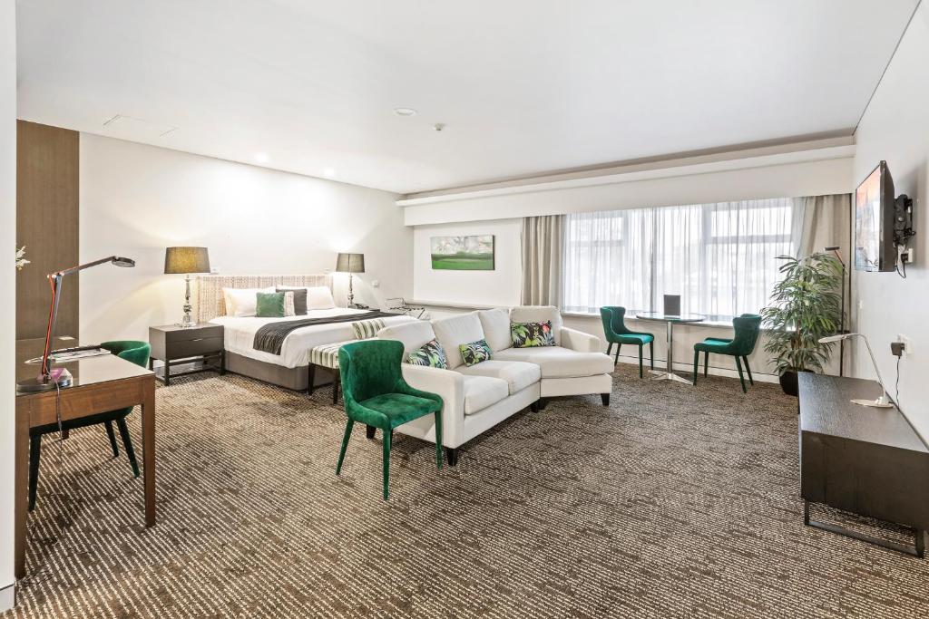 布里斯班考尔姆斯里酒店的酒店客房配有床、沙发和桌子。