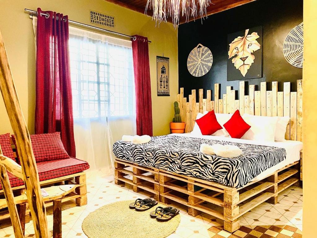 阿鲁沙Serengeti Villa的一间卧室配有一张带红色枕头的床和一把椅子