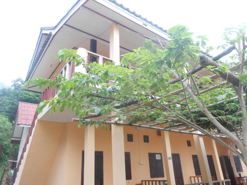 NongkhiawSythane Guesthouse的前面有棵树的建筑
