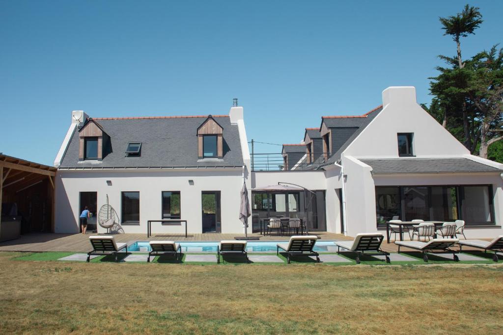 洛克马里亚La Villa Métairie的一座大型白色房子,前面设有一个游泳池