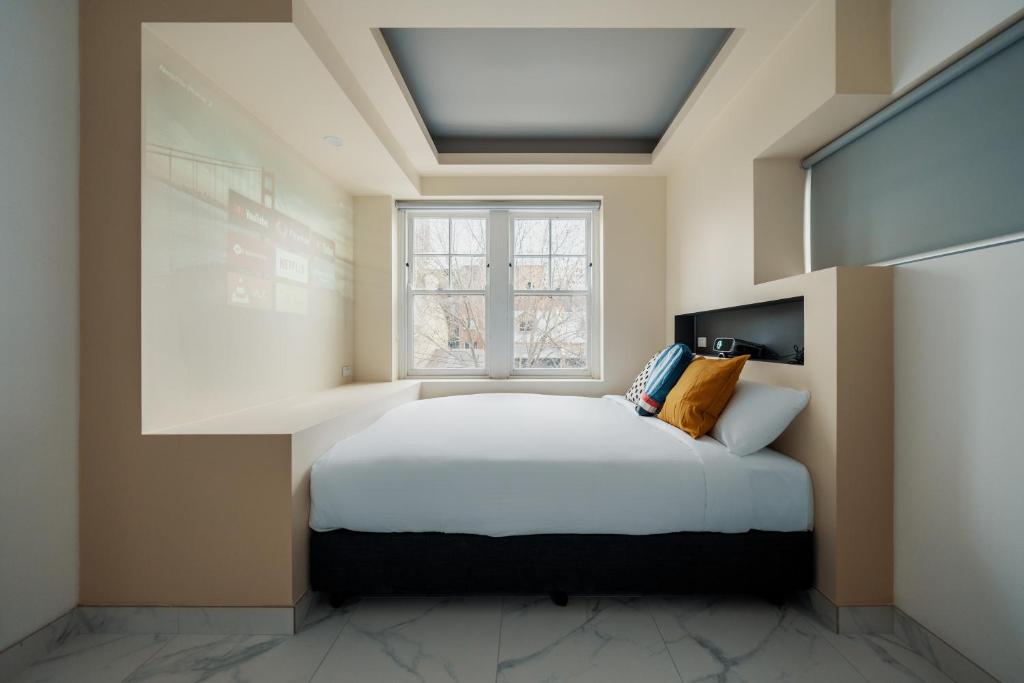 悉尼Cozy M Hotel的一间卧室设有一张床和一个窗口