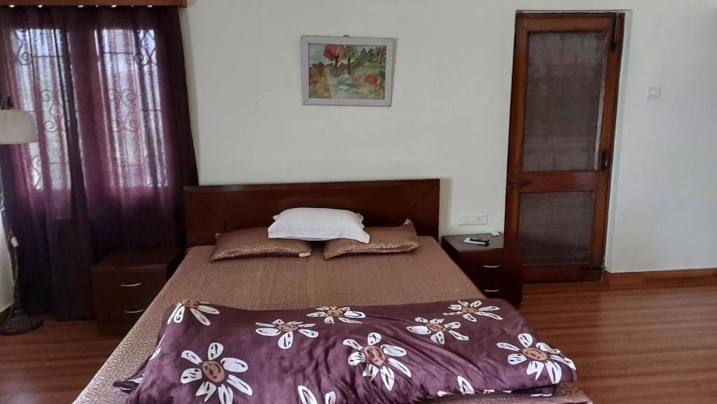 德拉敦vera home stay的卧室内的一张带紫色棉被的床