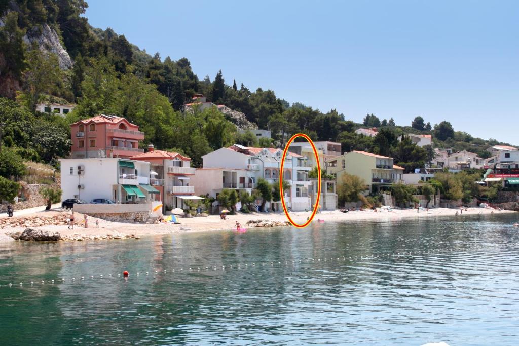 德朗西斯Apartments by the sea Drasnice, Makarska - 6652的海滩旁的水中的一个橙色物体