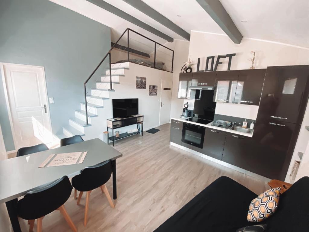 Bourg-Saint-ChristopheLoft and Studio and Love Room的厨房以及带桌子和楼梯的客厅。