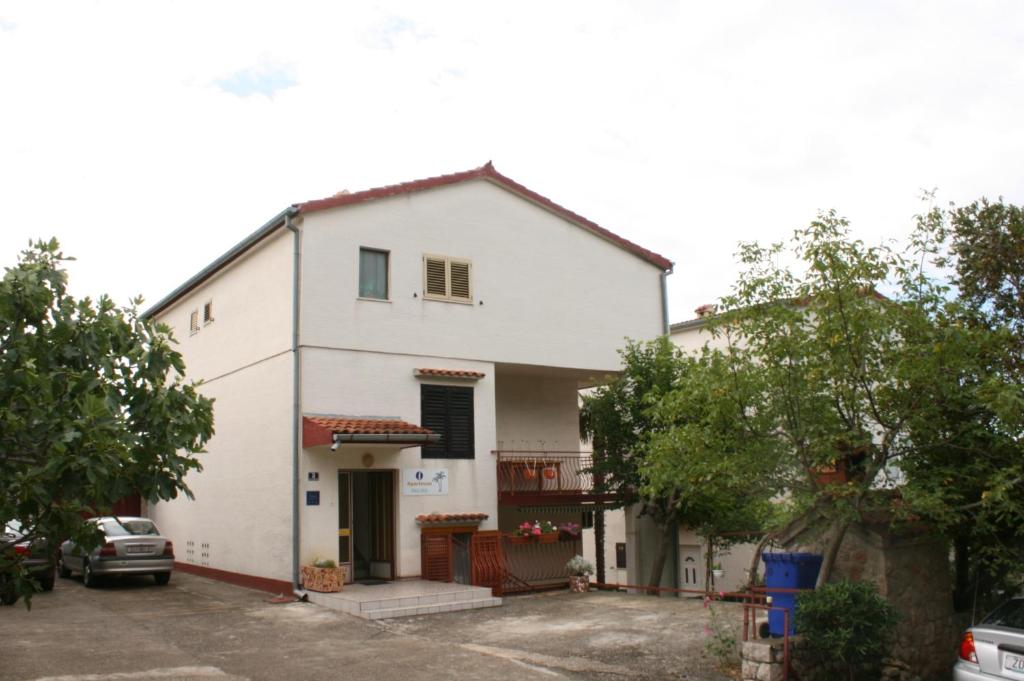 斯塔利格拉德-帕克利尼卡Apartments by the sea Starigrad, Paklenica - 6579的停车场内有停车位的白色房子