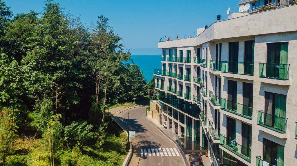 巴统Capo Verde Hotel Batumi的公寓大楼和海边的街道