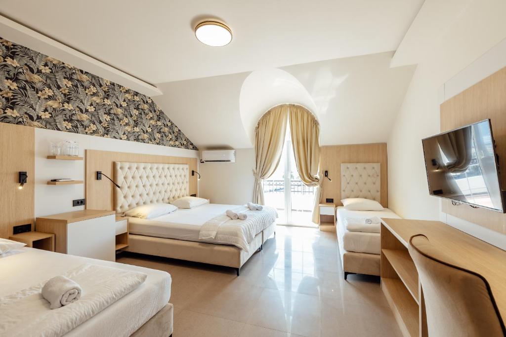 ŠpanjolaApartments Belani Zelenika的酒店客房设有两张床和一台平面电视。