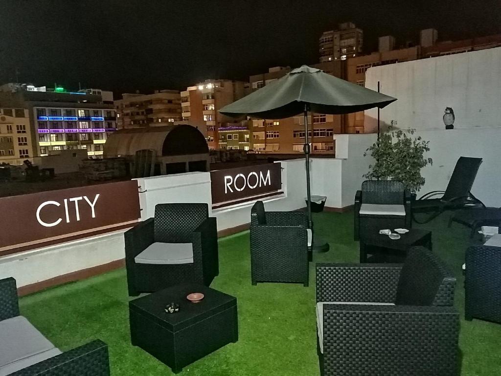 大加那利岛拉斯帕尔马斯City Room Las Palmas的屋顶上一组椅子和一把雨伞